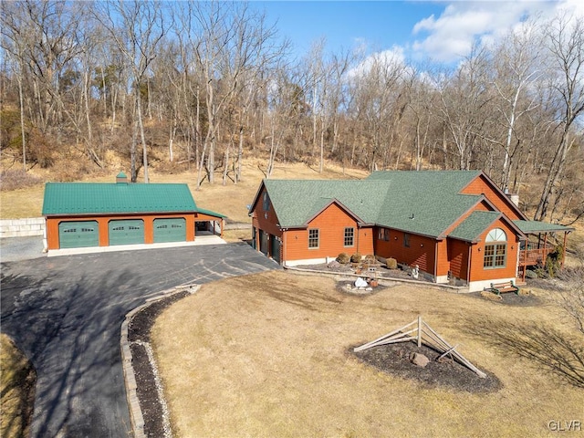 view of front of property featuring a garage, driveway, and roof with shingles