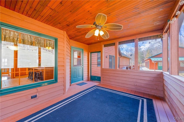 unfurnished sunroom featuring a ceiling fan and wooden ceiling