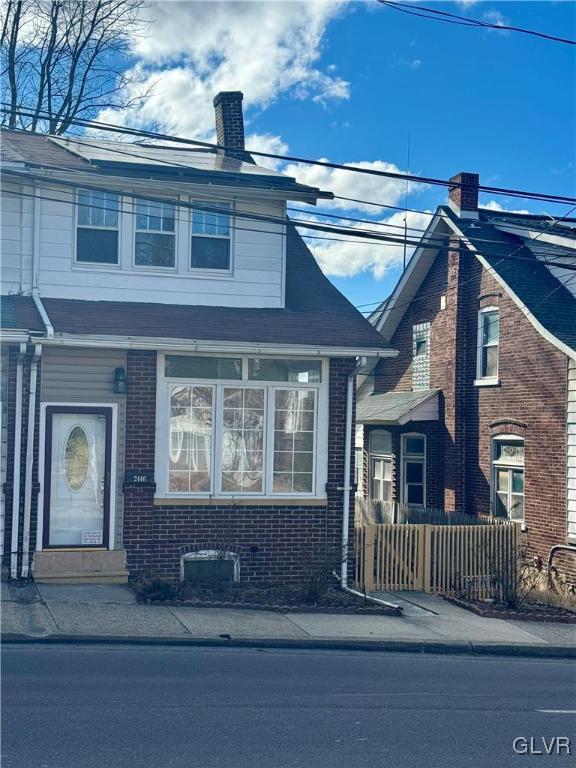 view of front of home featuring brick siding and a chimney