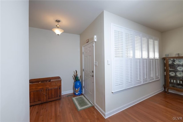 foyer with baseboards and wood finished floors