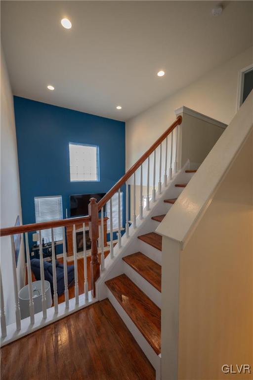 stairway with visible vents, wood finished floors, and recessed lighting