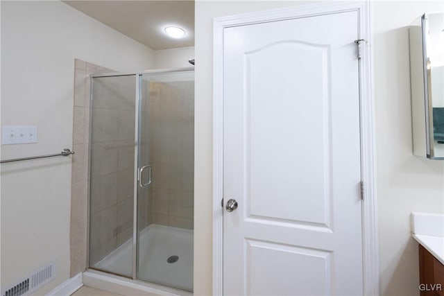 bathroom with visible vents, vanity, and a shower stall