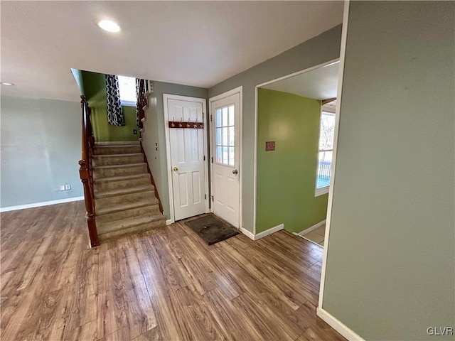 entryway featuring baseboards, stairway, and wood finished floors