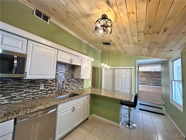 kitchen featuring light tile patterned floors, stainless steel appliances, tasteful backsplash, visible vents, and a sink