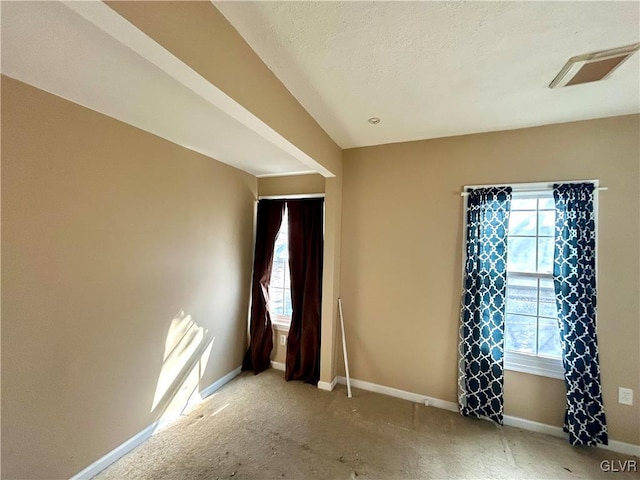 spare room with visible vents, a textured ceiling, and baseboards