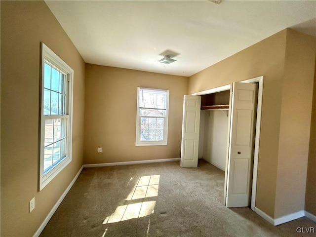 unfurnished bedroom featuring a closet, carpet flooring, and baseboards