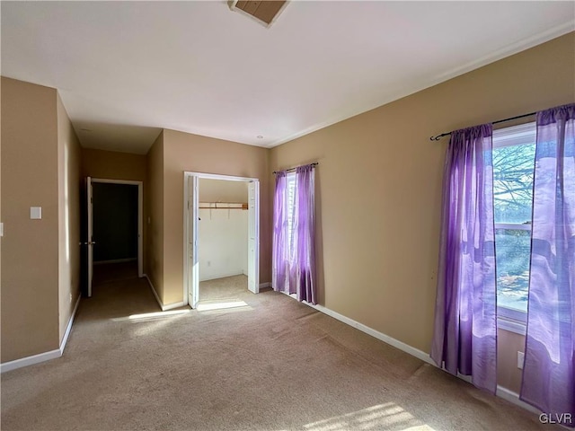 unfurnished bedroom featuring a closet, carpet flooring, visible vents, and baseboards