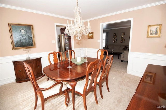 dining area with a wainscoted wall, crown molding, and light colored carpet