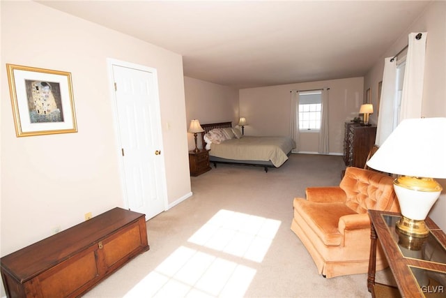 bedroom with baseboards and light colored carpet