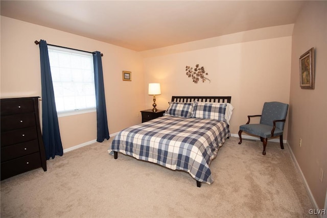 bedroom with light colored carpet and baseboards