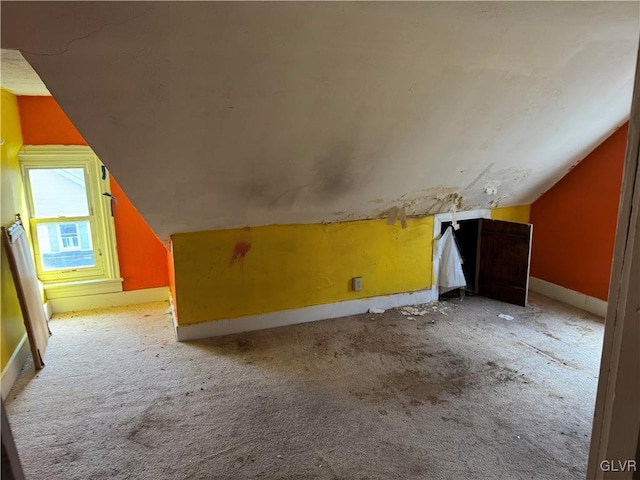 additional living space with light carpet, baseboards, and vaulted ceiling