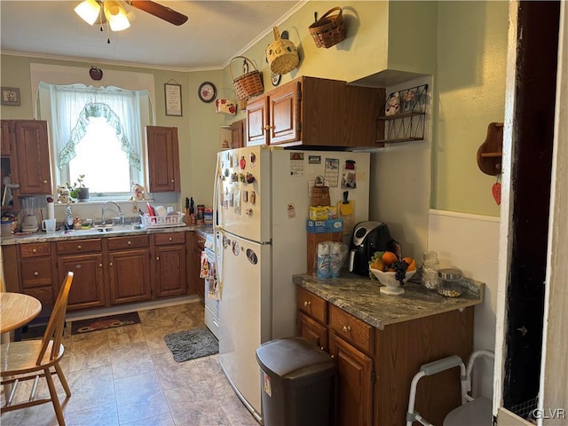 kitchen with brown cabinets, stove, a sink, and crown molding