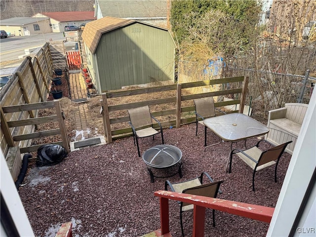 view of patio / terrace with an outbuilding, fence, and a storage unit