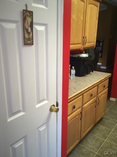 kitchen with dark tile patterned floors and light countertops