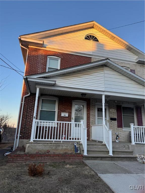 view of front of home featuring a porch and brick siding