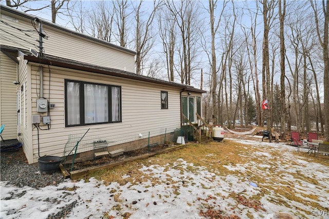 snow covered property with entry steps