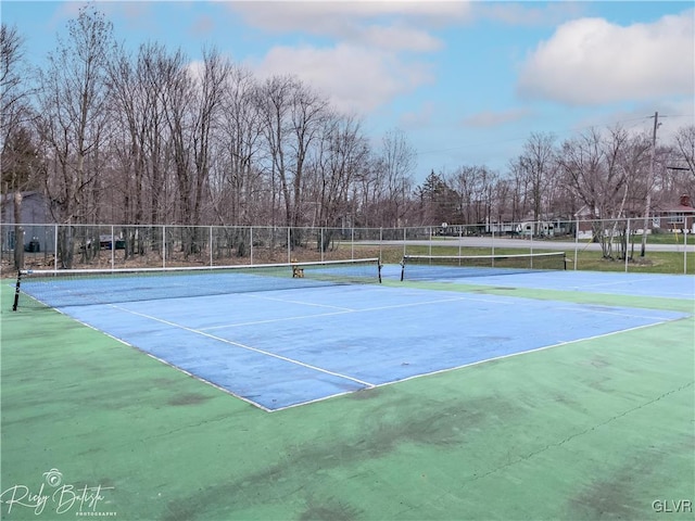 view of tennis court featuring fence