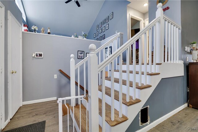 stairs with vaulted ceiling, wood finished floors, and baseboards