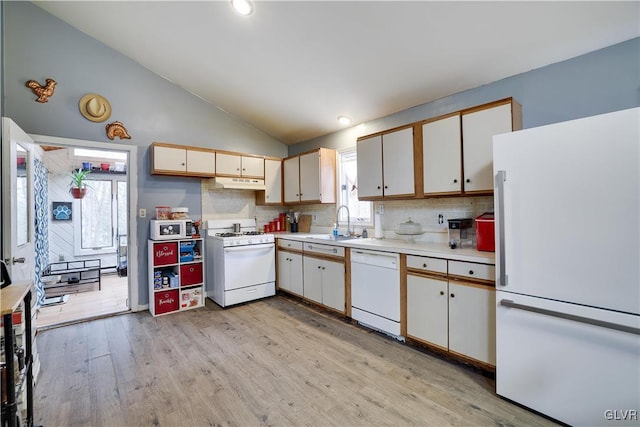 kitchen featuring white appliances, light wood-style floors, lofted ceiling, light countertops, and under cabinet range hood