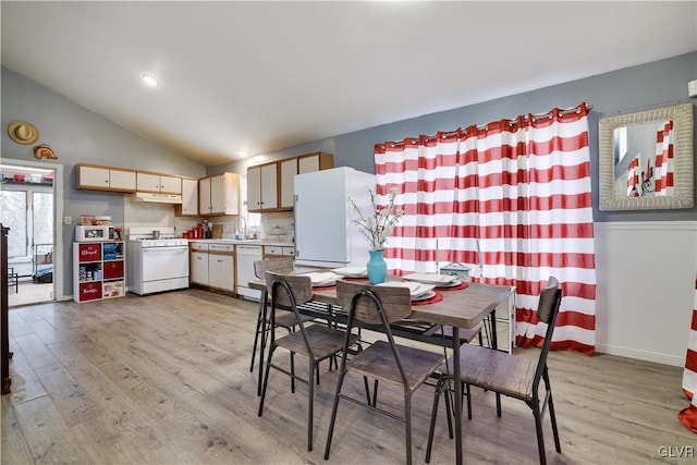 dining space featuring lofted ceiling, light wood-style floors, and baseboards