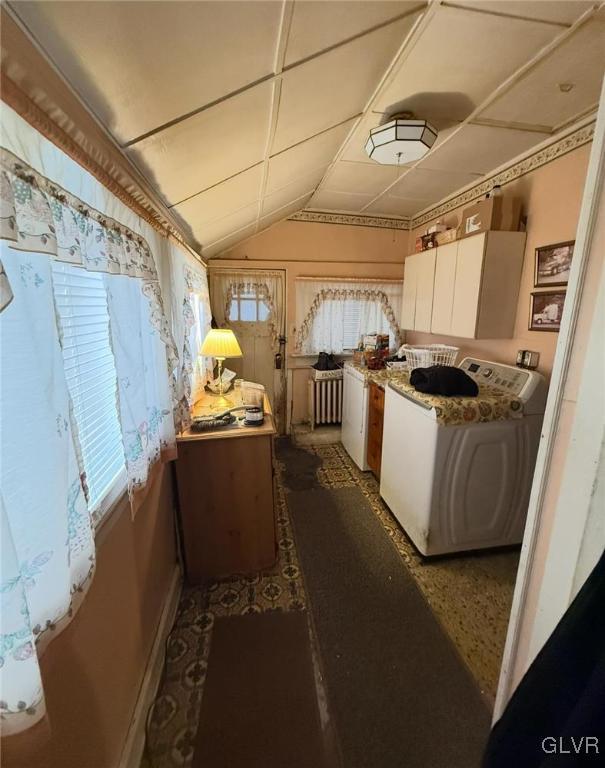 kitchen featuring washer / clothes dryer and vaulted ceiling