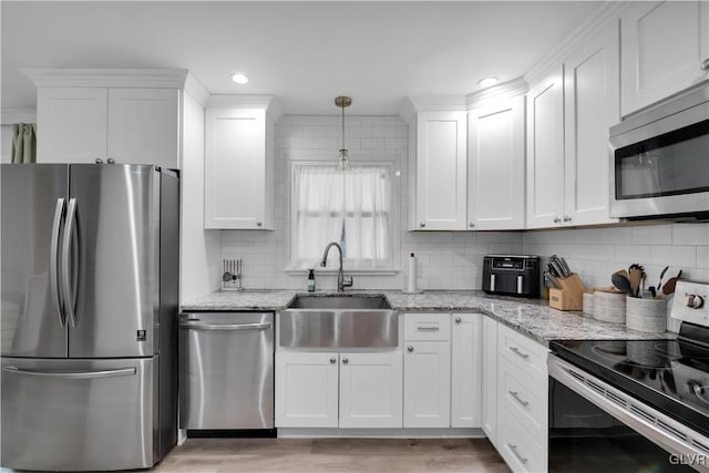 kitchen with stainless steel appliances, white cabinets, and a sink