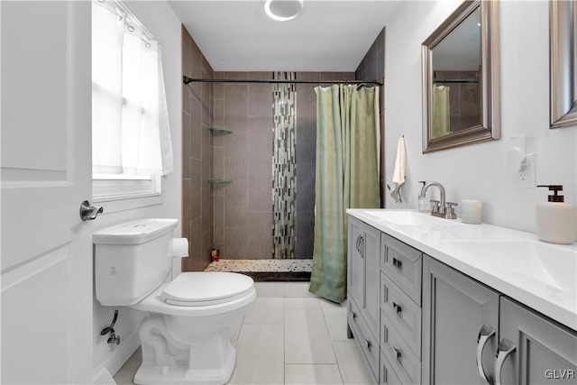 full bath with a sink, a tile shower, toilet, and double vanity