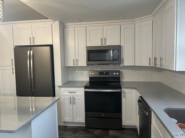 kitchen featuring white cabinetry, backsplash, and black appliances