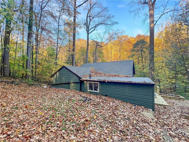 view of property exterior with a forest view