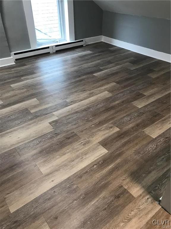 details with baseboards, baseboard heating, and wood finished floors