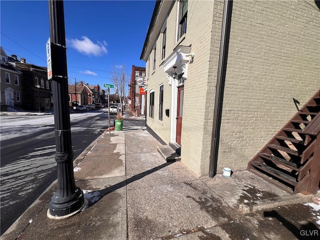 view of road with curbs, street lighting, sidewalks, and a residential view