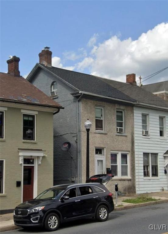 view of front of property with brick siding and a chimney