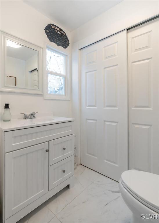 bathroom featuring marble finish floor, vanity, and toilet