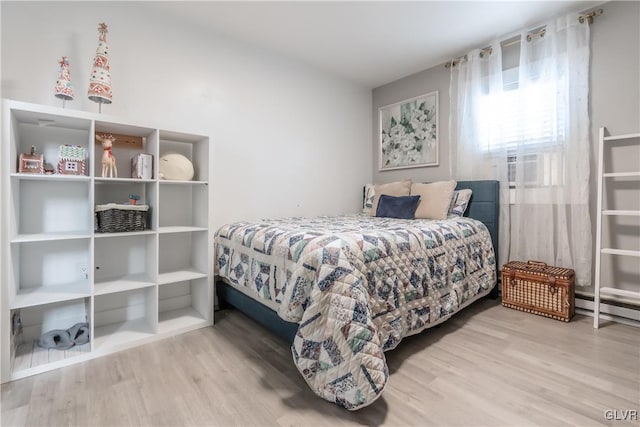 bedroom with cooling unit and wood finished floors