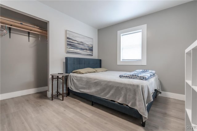 bedroom featuring a closet, baseboards, and wood finished floors