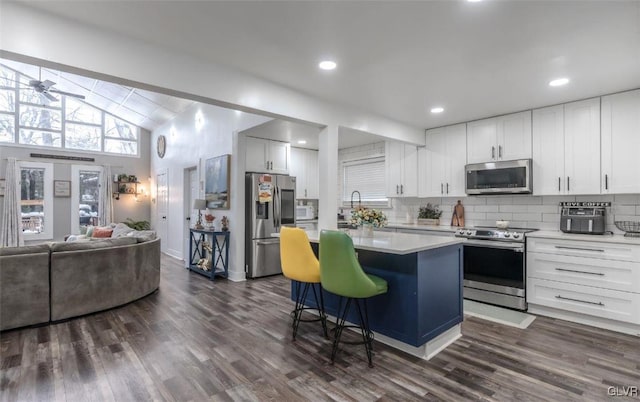 352 Scotch Pine Dr, Coolbaugh Twp, PA 18346 - kitchen featuring stainless steel appliances, vaulted ceiling, a kitchen island, dark wood finished floors, and a kitchen breakfast bar