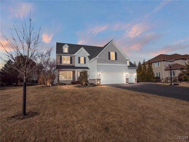 view of front facade featuring an attached garage, driveway, and a front lawn