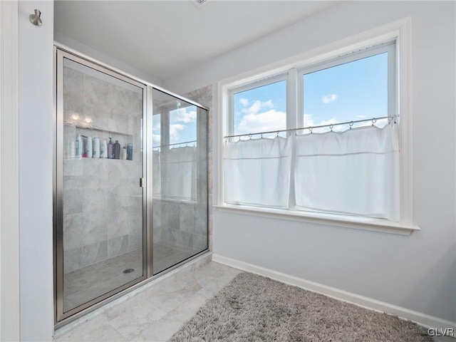 bathroom featuring a shower stall and baseboards