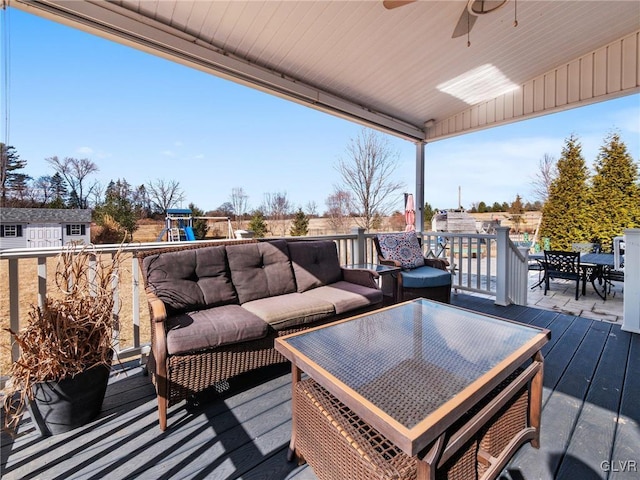 deck with a ceiling fan, outdoor dining space, a playground, and an outdoor living space