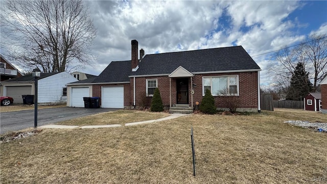 view of front of property featuring aphalt driveway, an attached garage, brick siding, a chimney, and a front yard