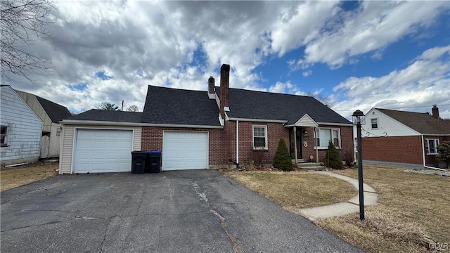 view of front of house featuring aphalt driveway, brick siding, roof with shingles, a chimney, and an attached garage