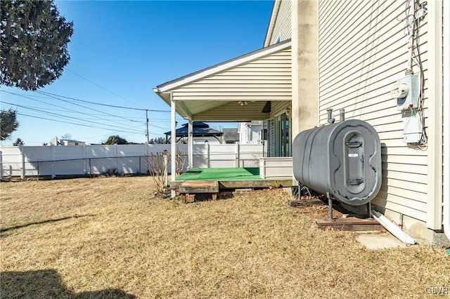 view of yard featuring fence and heating fuel