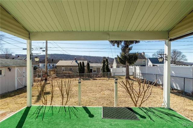 view of patio / terrace featuring an outbuilding, a fenced backyard, and a shed