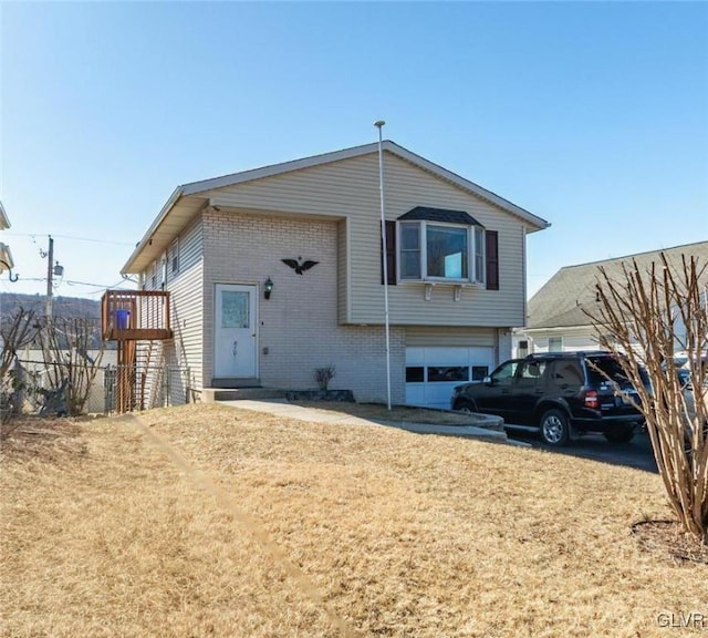 view of front of property with a garage, a front yard, and brick siding