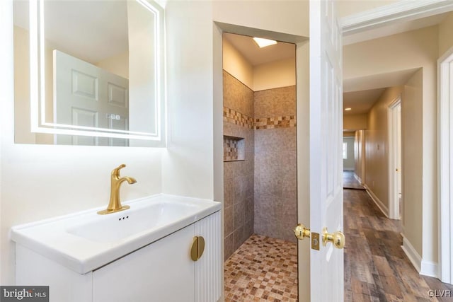 full bath with tiled shower and vanity