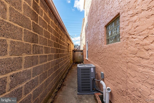 view of property exterior featuring fence and central air condition unit