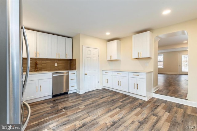 kitchen with stainless steel appliances, dark wood-type flooring, a sink, and light countertops