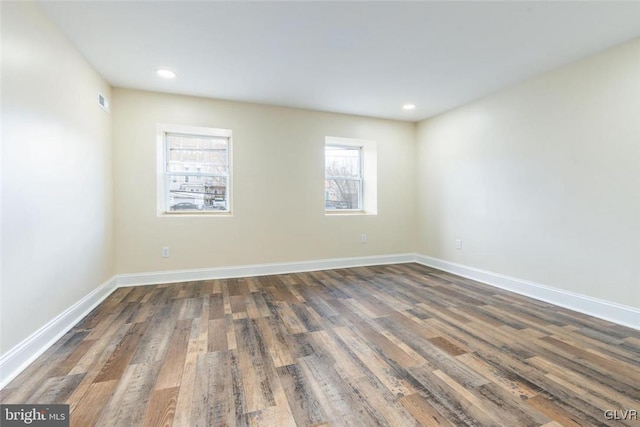 unfurnished room with dark wood-style floors, recessed lighting, and baseboards