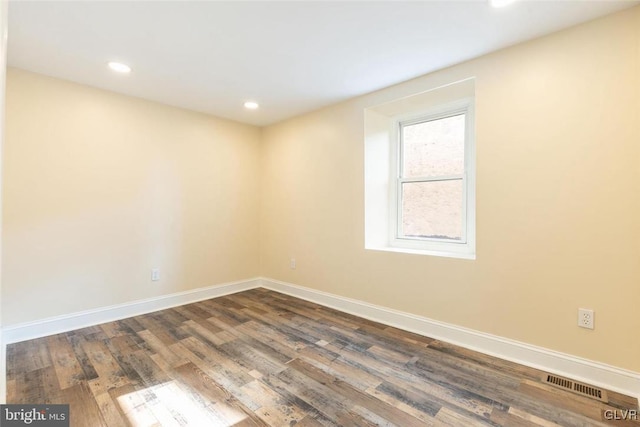 unfurnished room with dark wood-style flooring, recessed lighting, visible vents, and baseboards