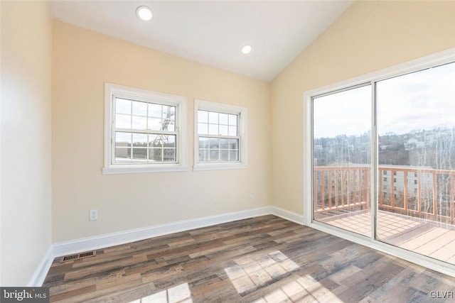 empty room with dark wood-style floors, lofted ceiling, baseboards, and recessed lighting